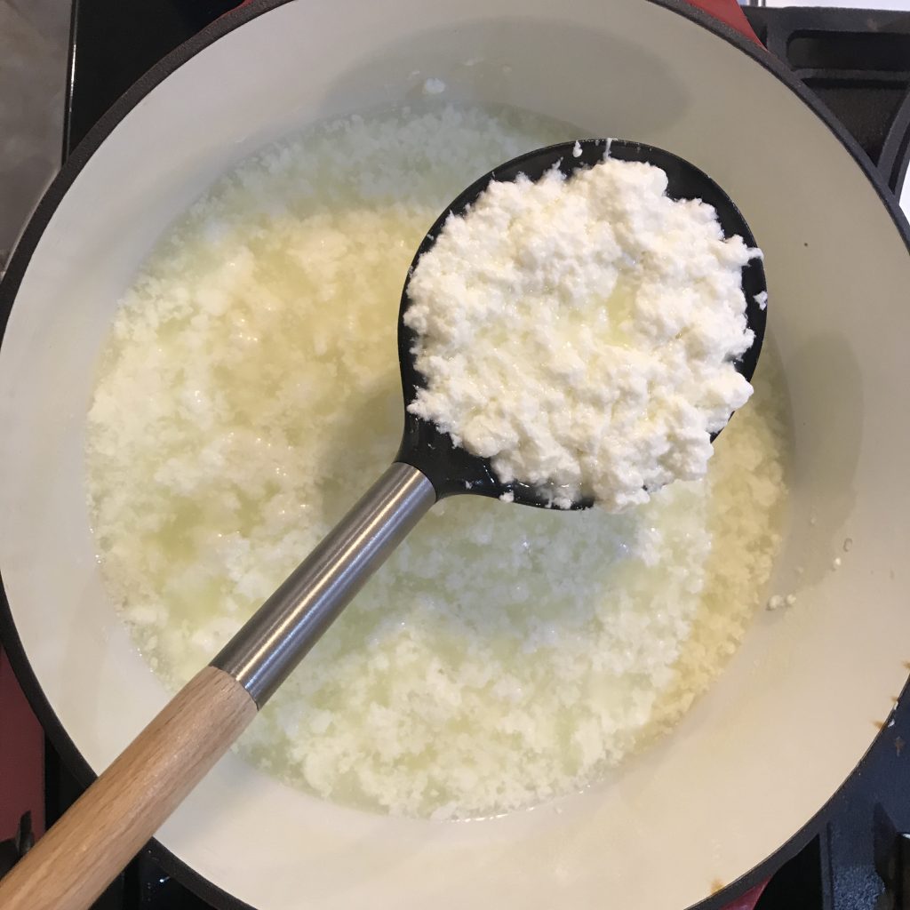 Ricotta in a slotted spoon