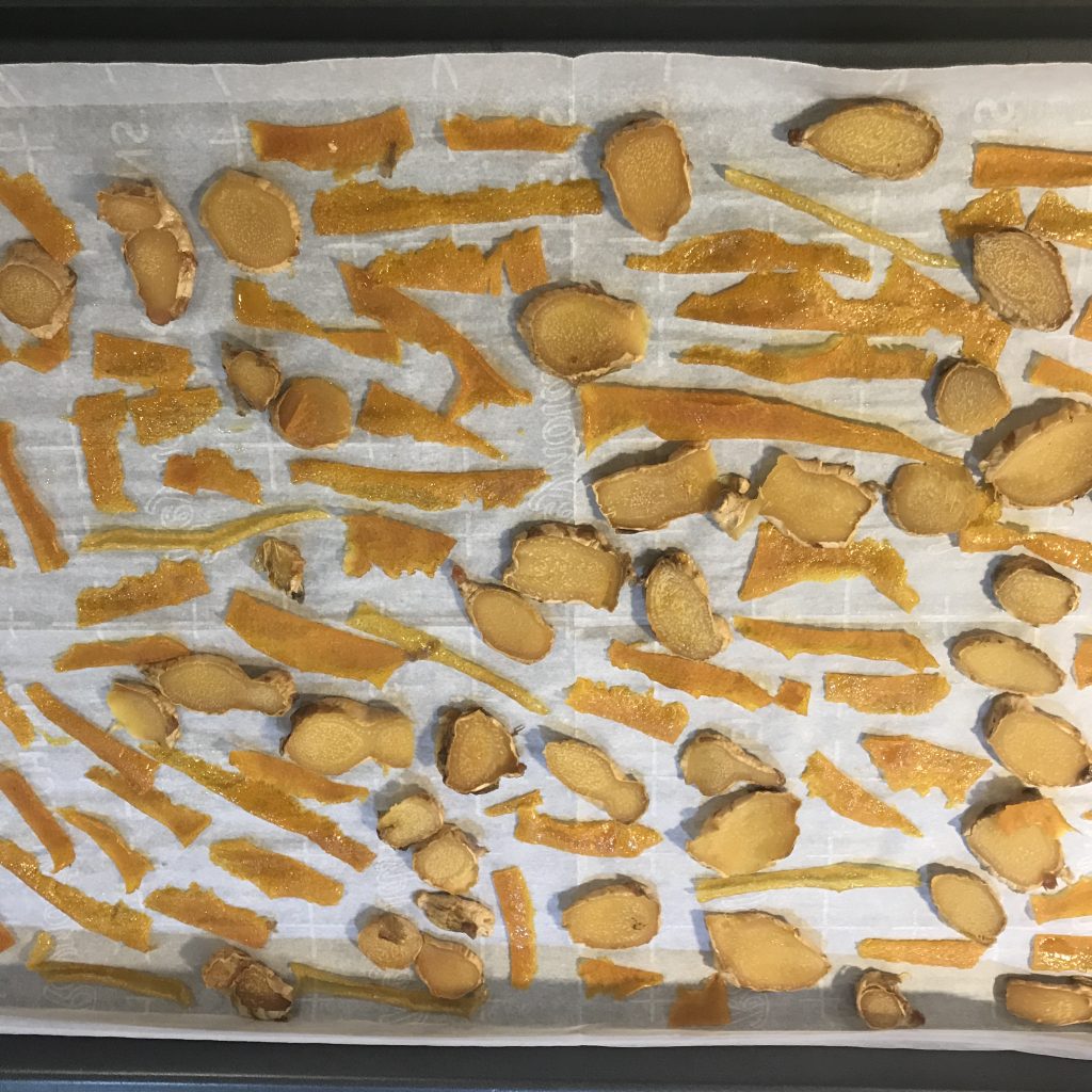 orange zest and ginger drying on a sheet pan